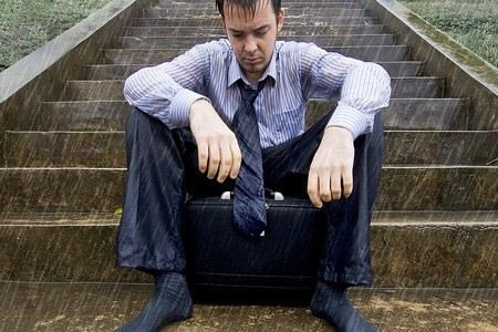 Мужчина сидит под дождем