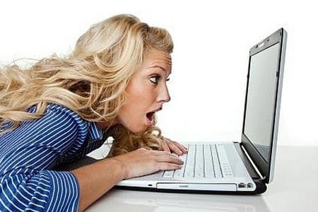 Женщина с открытым ртом смотрит в ноутбук