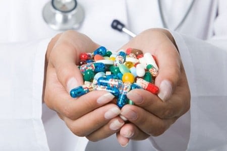 Капсулы и таблетки в руках врача