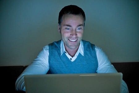 Мужчина смотрит на экран ноутбука