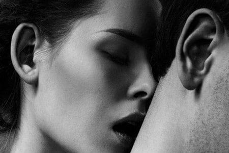 Женщина целует мужчину в шею