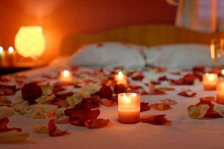 свечи и лепестки роз на кровати